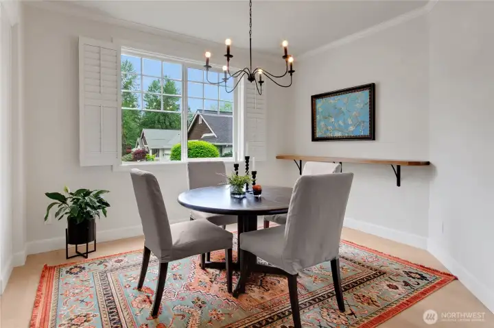 Designer lighting and plantation shutters frame a large picture window overlooking the delightful front yard.