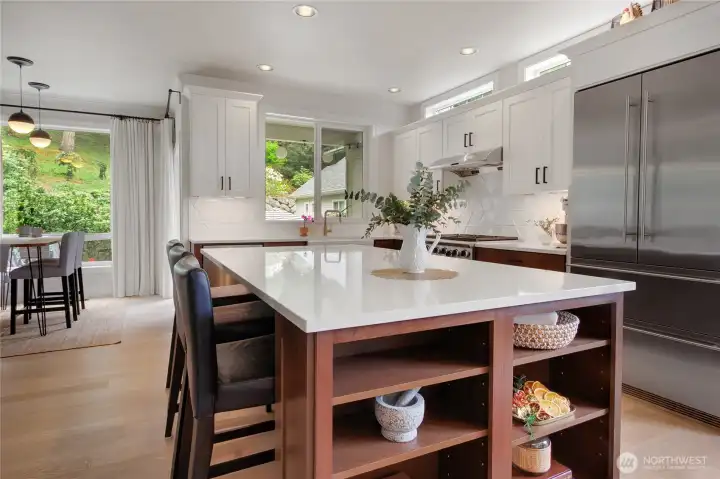A large center island anchors the kitchen with not only useful storage space but serves as bar counter seating perfect for morning coffee, snack time or casual meals.