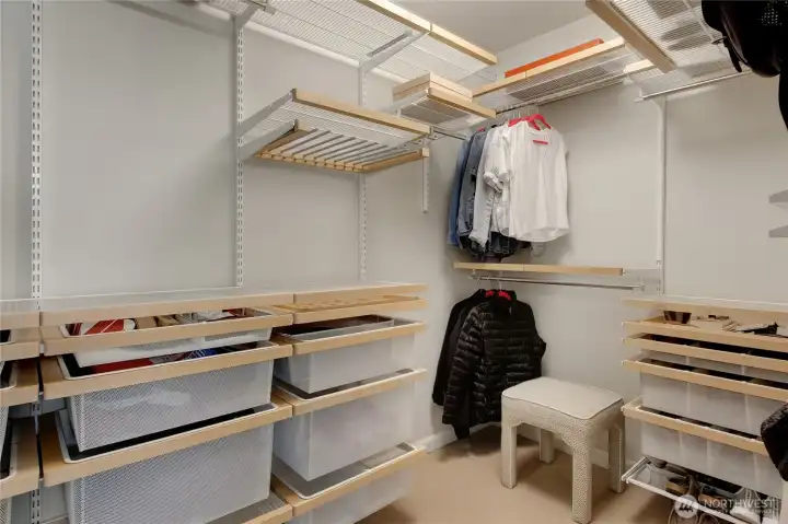 Large walk-in closet offers custom closet organizers to keep your personal belongings neat and tidy.