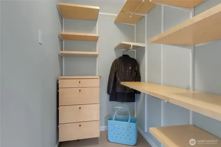 Another walk-in closet continues with organizing shelves and drawers.