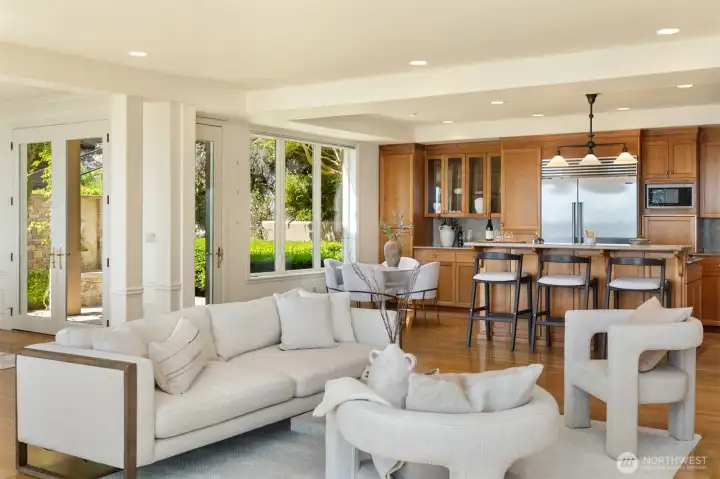 View of the living, kitchen with its eating nook and the multiple doors to the courtyard.