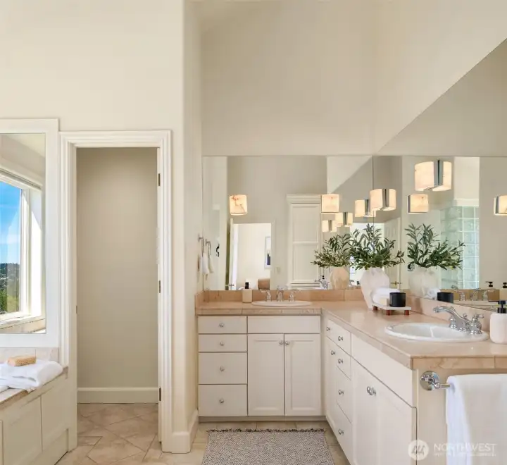 Primary bathroom complete with dual sinks, shower with glass blocks and soaking tub.