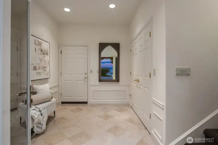 Main entrance with travertine tile and leading to the garages.