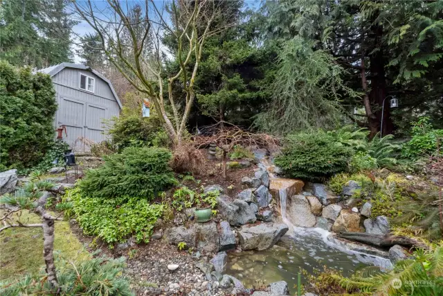 An incredible multitiered fountain.  This really sounds like a quiet mountain stream. Small sanctuary sitting area behind fountain.  High quality storage shed in background.