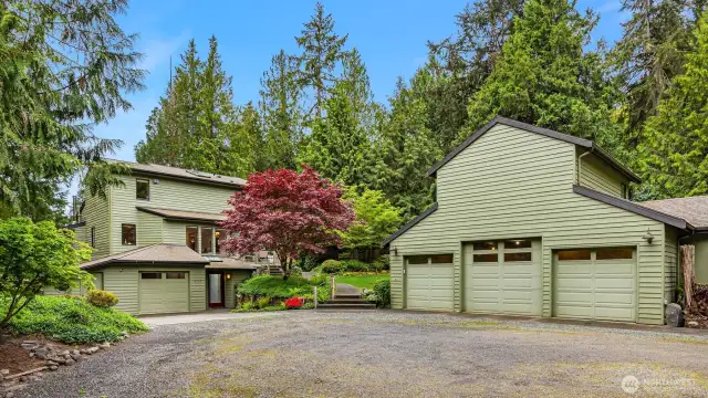 Detached 4 car garage has an upper level workshop with 1/2 bath