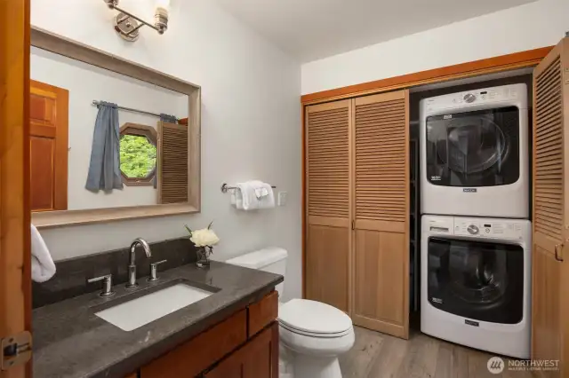 Main floor bathroom with stackable washer and dryer that convey.