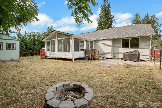 Large back yard with BBQ pad fire pit and shed.