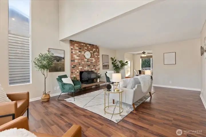 A multi-functional living space with masonry fireplace, leading into the dinning room.