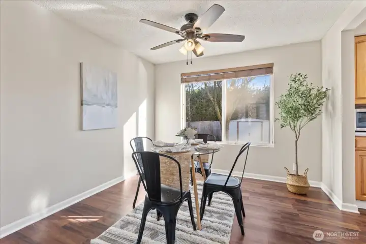 Dining room with updated ceiling fans, light fixtures and blinds.