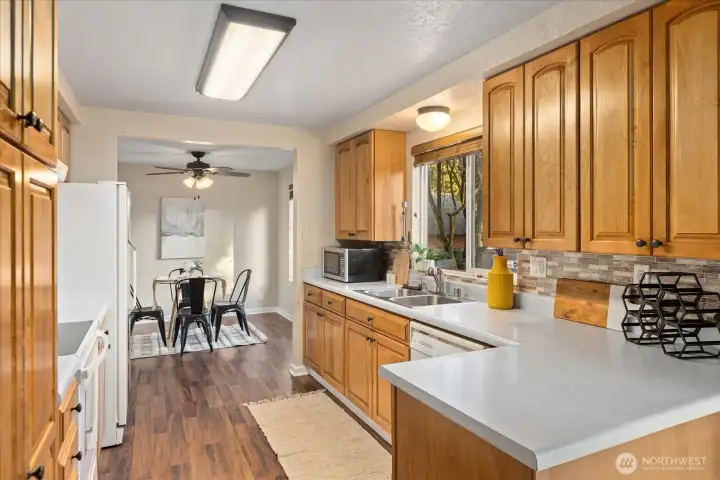 Kitchen features laminate flooring, natural lighting and Whirlpool appliances. All will stay.