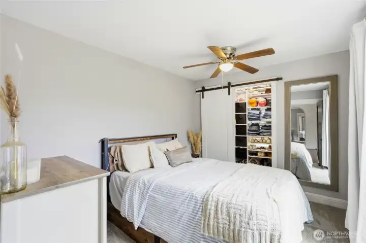 Primary bedroom with ceiling fan, medium sized closet with barn door and private access to backyard deck