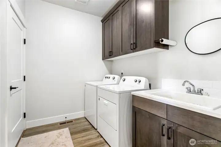 Spacious laundry room with extra storage, a convenient sink, and a bonus—washer and dryer included!
