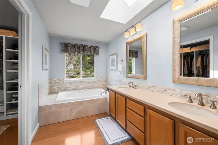 Primary bathroom with corian countertops and large soaking tub.