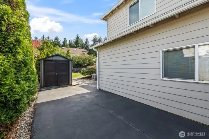 Extra parking on side of home with an outdoor shed for your landscaping tools.