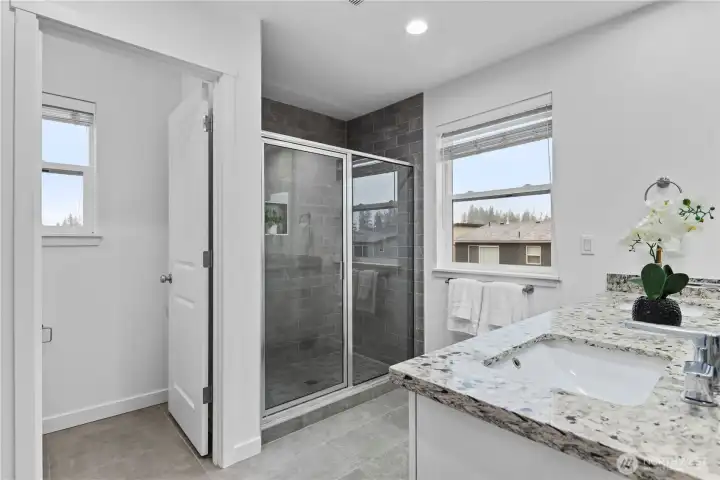 Primary ensuite with water closet, tiled shower, and double vanity.