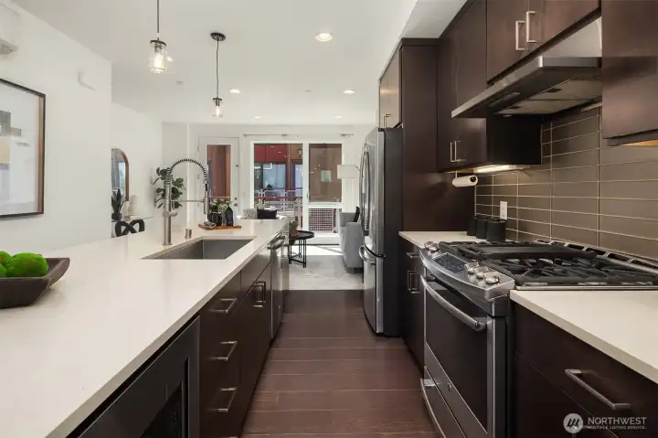 Spacious kitchen with slab quartz countertops, massive center island, full height backsplash & SS appliances. Spacious kitchen with slab quartz countertops, massive center island, full height backsplash & SS appliances.