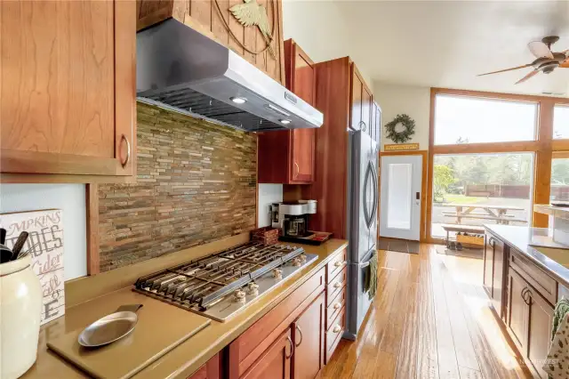 This amazing kitchen has a gas range and oven, built in large fridge, gorgeous cabinetry, bamboo flooring, and beautiful tile and woodwork.