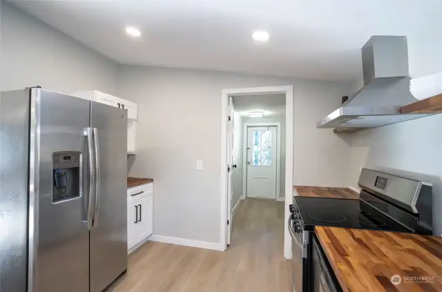 The kitchen offers additional cabinetry and expanded counter space conveniently located next to the refrigerator for enhanced storage and functionality.