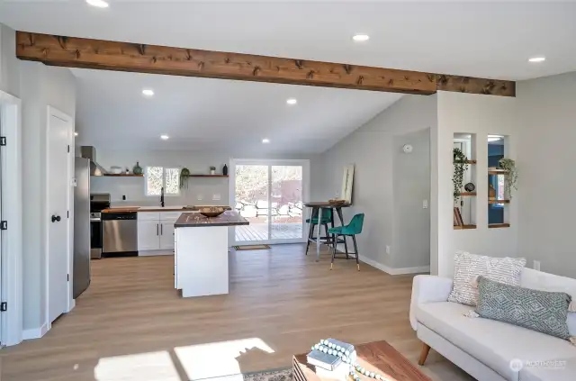 Another stunning view of the open-concept living space, featuring elegant built-in shelving perfect for showcasing your favorite decor. The newly installed, large sliding door opens to the enormous back yard.