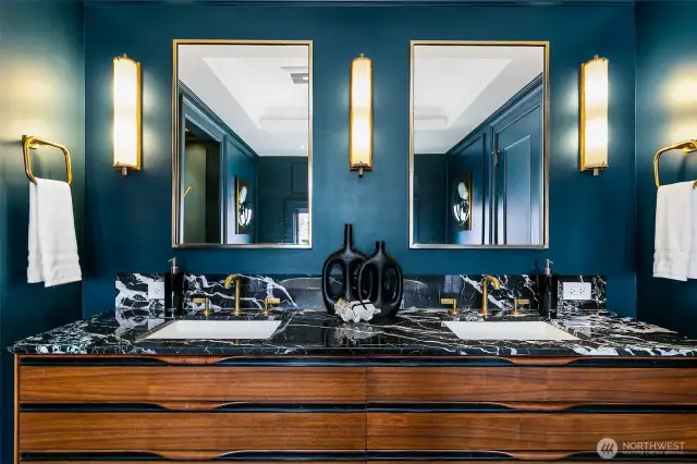 The En Suite Bath/Dressing Room continues its refined palette with twin vanities in warm walnut, veined Nero Marquina marble, and antique brass fixtures. Framed mirrors and fluted sconces echo the Art Deco vernacular—luxury with lineage, elevated for modern living.