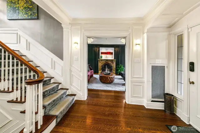 A reception hall with stately proportion and luminous calm. Original quarter-sawn oak floors glow beneath crisp millwork, while sightlines lead the eye to the solarium beyond—an orchestrated prelude to the mansion’s rhythm of elegance and ease.