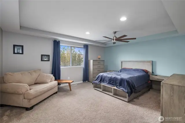 Primary BR - spacious, a tray ceiling and an overhead fan.