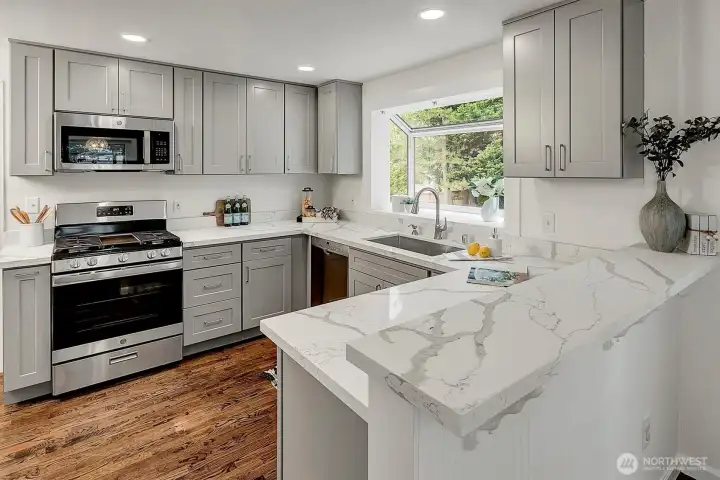 The newly remodeled kitchen boasts quartz countertops, shaker cabinetry, new stainless steel appliances.