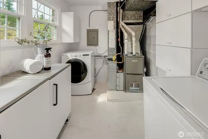 Utility room with a newer HVAC and many storage cabinetary.