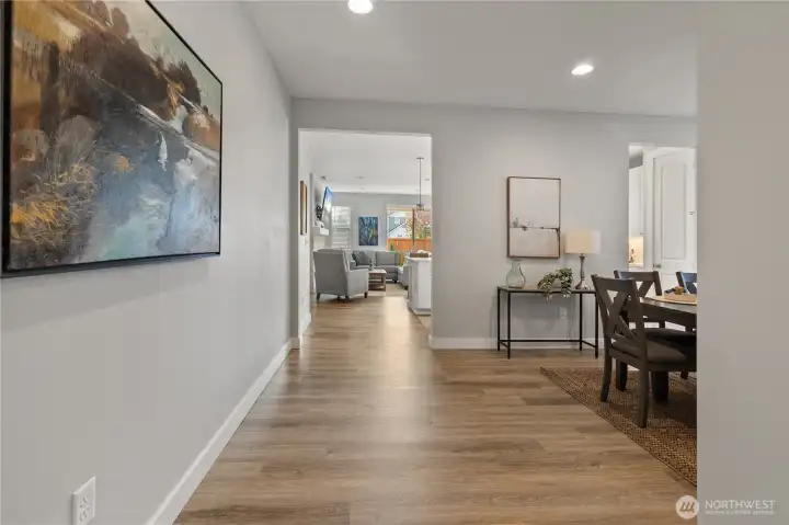 Welcoming Entryway – Bright and spacious with warm wood-style floors, this inviting hallway opens to the dining area and great room, setting the tone for the home’s open-concept design.
