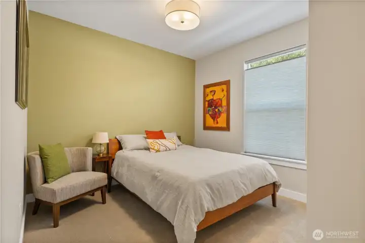 Inviting Guest Retreat – Freshly painted with a soothing green accent wall, this comfortable guest bedroom offers plush carpet, a large window for natural light, and ample space for a queen bed and seating. Perfect for visitors, a home office, or flex space.