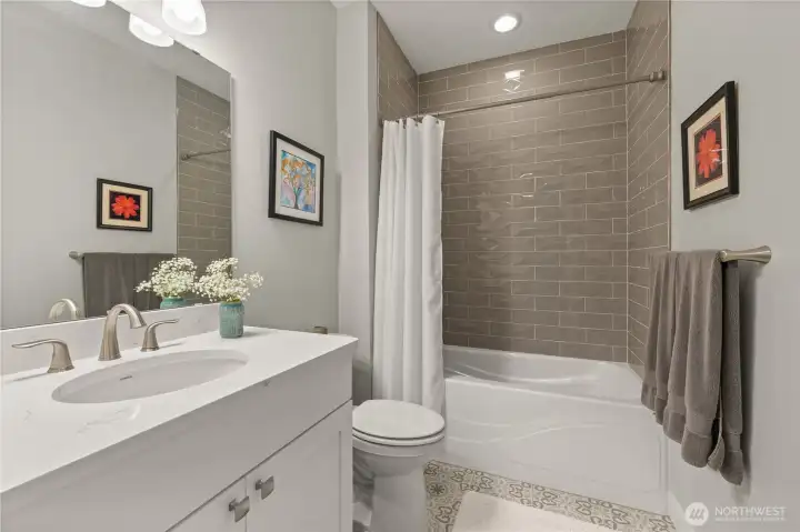 Stylish Guest Bath – Crisp and modern with updated tile surround, elegant quartz vanity, and contemporary fixtures. Perfectly located for guests or daily use.