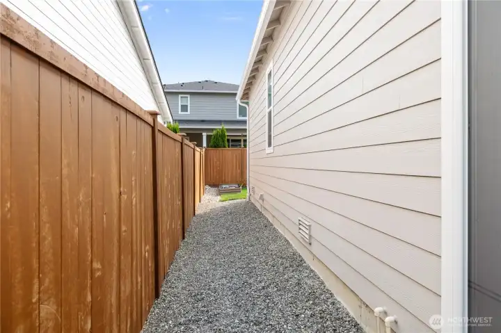 Side Yard – Fully fenced side yard with low-maintenance rock ground cover for easy care and extra outdoor storage space.