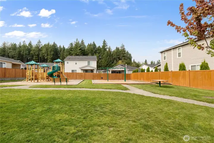 Neighborhood Green Space – Open grassy area with playground and picnic tables, perfect for gatherings, playtime, or enjoying the outdoors.