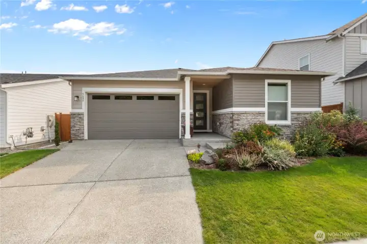 Inviting Curb Appeal – Modern single-level home with stone-accented façade, covered entry, and low-maintenance landscaping for easy year-round care.
