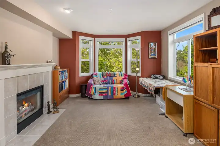 Inviting great room features a cozy gas fireplace with tile surround and mantle for display.  Bay windows look out to green city and territorial views.  Clerestory windows offer extra light.