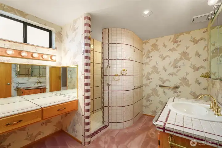 Primary bath with lighted vanity and walk in shower.