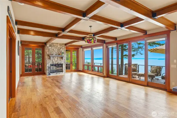 Beautiful, beamed ceilings and a stone fireplace with accented by hickory hardwood flooring, west facing views