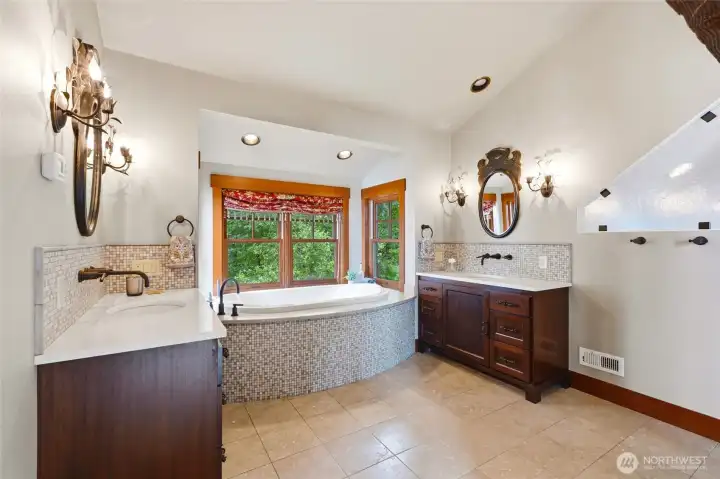 Custom  dual vanities with designer light fixtures complete the spa like bathroom