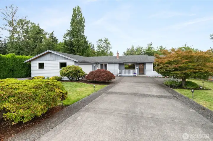 Long driveway, mature landscaping, and a stunning 50-year-old maple tree create exceptional curb appeal and a welcoming first impression.