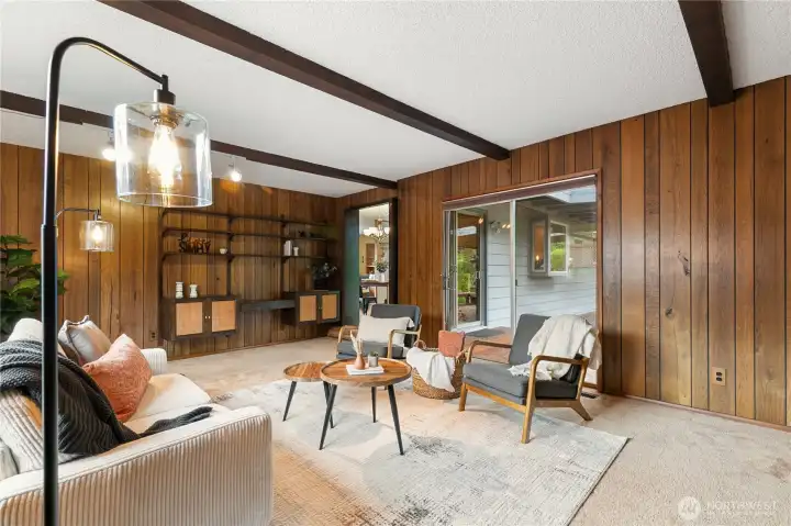Exposed beams and custom built-in shelving give this inviting family room its own distinctive character, while sliding glass doors provide easy access to the back patio.
