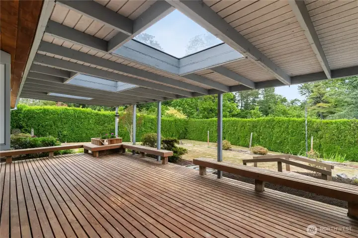 Expansive covered patio with built-in seating creates the perfect setting for outdoor entertaining. Skylights overhead fill the space with natural light, making it ideal for gatherings anytime of the year.