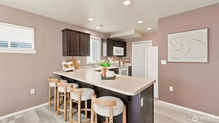 Step into a bright and inviting space featuring a modern open-concept kitchen with rich espresso cabinetry, a spacious island, and gorgeous light flooring Step into a bright and inviting space featuring a modern open-concept kitchen with rich espresso cabinetry, a spacious island, and gorgeous light flooring
