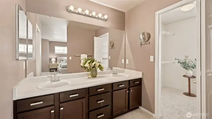 This primary bathroom has it all: tons of counter space, a sleek dual vanity, and a generously sized walk-in closet. This primary bathroom has it all: tons of counter space, a sleek dual vanity, and a generously sized walk-in closet.