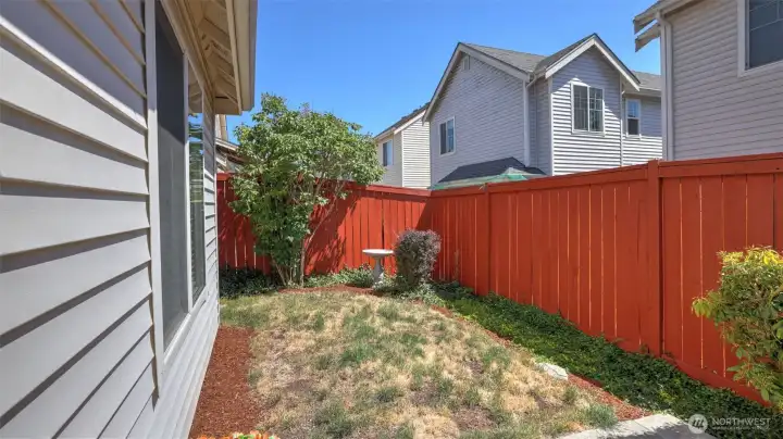 Step outside to a sunny, fully enclosed yard complete with a charming birdbath and mature landscaping Step outside to a sunny, fully enclosed yard complete with a charming birdbath and mature landscaping