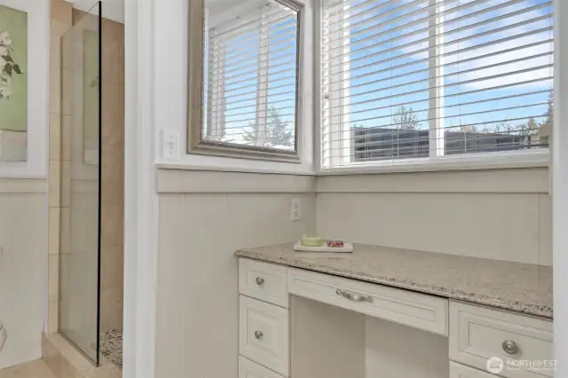 Ensuite bathroom with extra countertop space and windows for natural light.