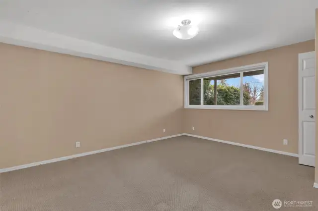 Second primary suite on the lower level with window to the front yard/gardens. This suite has 2 walk in closets for storage and an ensuite bathroom.