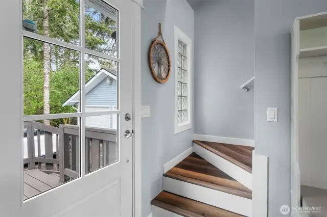 Staircase leading upstairs is right next to the front entrance and porch.