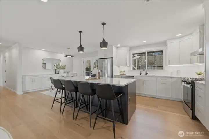 The heart of the home -- a fully remodeled chef's kitchen centered around an expansive quartz island perfect for gathering. Refined finishes, statement lighting and brushed gold accents create a space that feels both elevated and inviting.