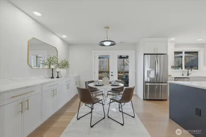 Dining area showcasing handcrafted hickory floors and custom quartz-topped built-ins with abundant storage, pullout drawers, an integrated outlet and a convenient interior-to-exterior pet door.