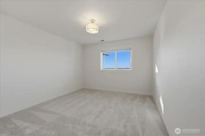 One of three upper-level bedrooms featuring brand new plush carpet, cordless blackout blinds and updated closet doors and hardware.